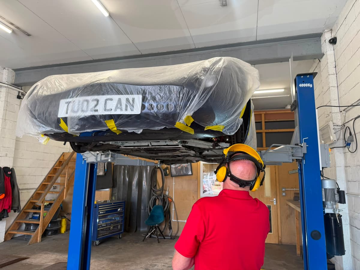 Car masked and taped on the lift before dry ice blasting begins